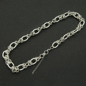 Close-up of silver chunky link necklace with textured oval rings and lobster clasp detail