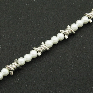Gros plan d'un collier punk avec perles blanches et maillons en fil de fer barbelé argenté