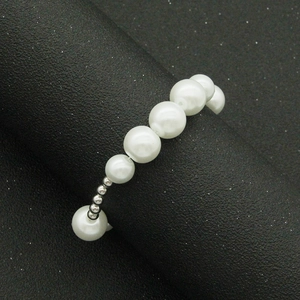 Détail d'un bracelet de perles minimaliste avec perles argentées sur support noir