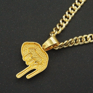 Détail macro d'une chaîne cubaine dorée avec un pendentif tête de gorille en strass