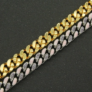 Détail de chaînes cubaines or et argent avec incrustation d'émail violet sur fond noir