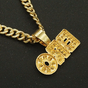 Vue macro d'une chaîne à maillons dorée hip-hop avec pendentif gravé OBD et texture