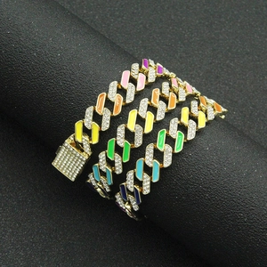 Close-up of colorful drip oil Cuban link chain with sparkling rhinestones on black background