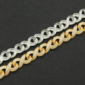 Macro shot of silver metal and gold crystal-encrusted infinity links for Cuban chain bracelet