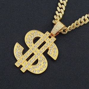 Close-up of gold-plated iced out dollar sign pendant on a thick Cuban link chain