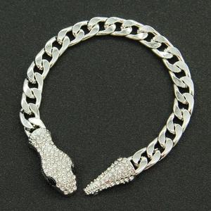 Detailed view of silver curb chain bracelet featuring rhinestone-encrusted snake head clasp