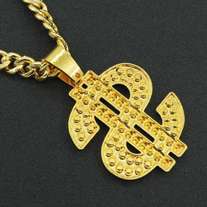 Macro shot of hip hop gold dollar sign pendant with textured details on a twist chain