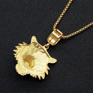 Gros plan du pendentif tête de tigre doré punk avec surface texturée et chaîne