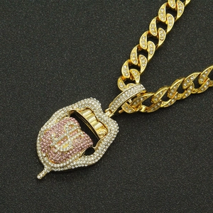 Gros plan sur collier chaîne cubaine hip-hop dorée avec pendentif langue signe dollar