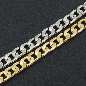Detailed view of Cuban link chains in polished silver and gold finishes on a dark surface