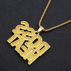 Gros plan du pendentif hip hop doré avec cristaux givrés sur un fond en maille noire
