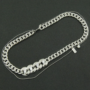 Détail d'un collier argenté à double épaisseur avec chaîne gourmette, zircons et une perle