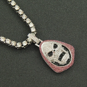Détail macro du pendentif tête de mort hip hop serti de cristaux roses sur chaîne tennis