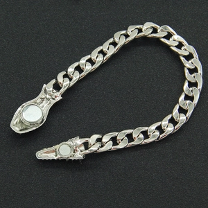 Detail of silver Cuban chain necklace featuring a textured magnetic clasp and polished finish