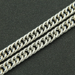 Détail d'un bracelet gourmette argenté avec une finition métallique polie et lisse