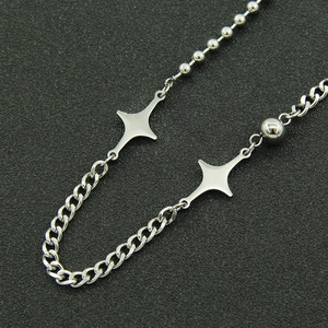 Silver punk style Cuban link necklace featuring minimalist star pendants on black background