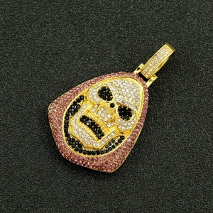 Gros plan sur pendentif tête de mort hip hop avec strass roses et blancs sur fond noir