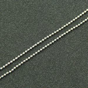 Gros plan d'un collier à double chaîne à billes argentées avec finition polie