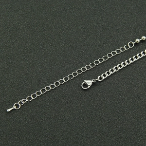Detail of silver cuban chain lobster clasp with extender and metal droplet pendant