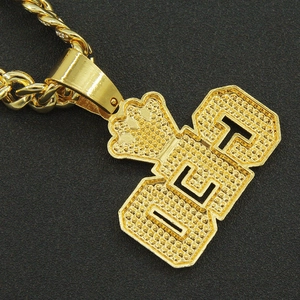Vue détaillée du pendentif lettre OCT dorée avec cristaux micro-pavé sur chaîne torsadée