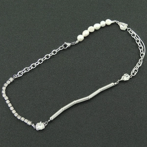 Chic silver Cuban link necklace featuring pearls and rhinestones on a dark textured surface