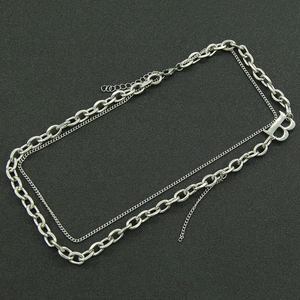 Double-layered silver Cuban chain necklace featuring a bold metal B pendant and O-chain style