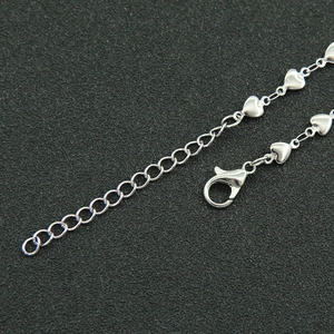 Detail of silver titanium steel necklace featuring heart link, lobster clasp and extension