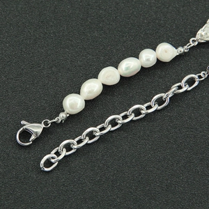 Close-up of baroque pearls and silver titanium steel Cuban chain with lobster clasp