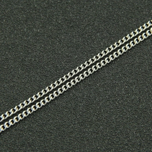 Macro shot of silver dual-layer curb chain showing polished steel texture and link detail