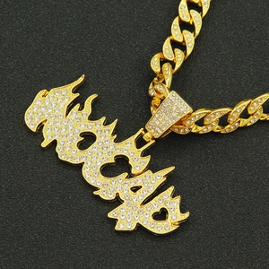Iced out gold hip hop necklace featuring fire letter pendant and Cuban link chain