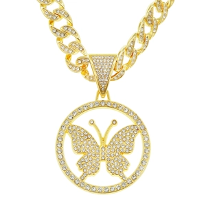 Close-up of golden iced-out butterfly pendant on a sparkling Cuban link chain necklace