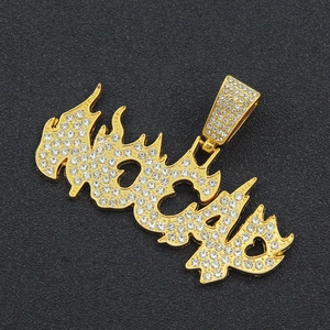 Detail of hip hop gold flame pendant with sparkling white rhinestones on black background
