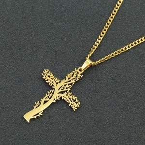 Vue macro d'un pendentif croix dorée avec arbre de vie sur une chaîne cubaine