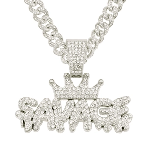 Macro detail of iced out SAVAGE pendant with crown and diamond encrusted Cuban chain