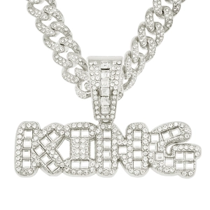 Gros plan détaillé du pendentif KING avec zircons baguettes sur une chaîne cubaine