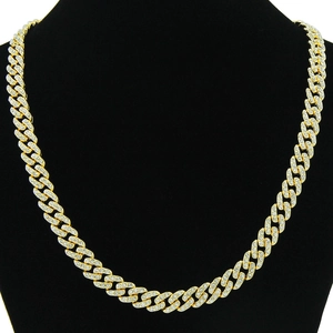 Vista macro della catena cubana da 9mm in oro con diamanti pavé su un busto nero lucido