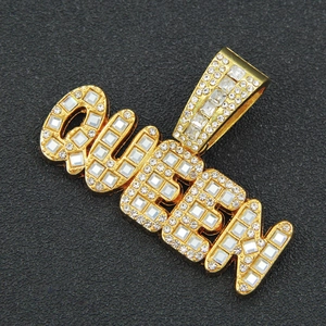 Macro shot of gold-plated QUEEN letter pendant with pavé crystals on Cuban chain