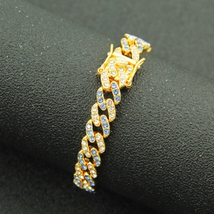 Dettaglio macro del bracciale a catena cubana in oro 9mm con cristalli blu e bianchi hip-hop