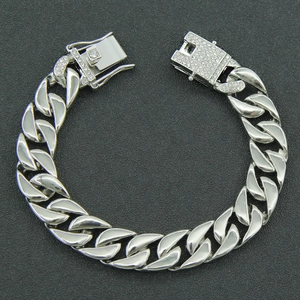 Macro detail of silver Cuban link chain featuring a sparkling iced out butterfly buckle