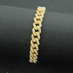 Vista macro del bracciale a catena cubana dorata da 9mm con strass luccicanti incastonati