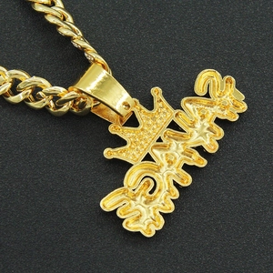 Macro shot of hip hop gold crown letter pendant with thick Cuban link chain