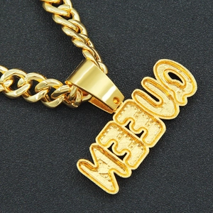 Macro detail of gold JESUS letter pendant with textured finish on thick curb chain
