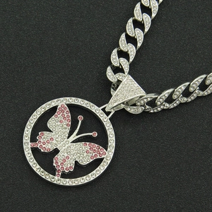 Close-up of hip hop Cuban chain necklace with iced out pink butterfly pendant in silver