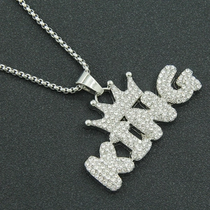 Hip hop silver crown KING pendant necklace with pavé crystals on grey textured background