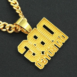 Gros plan du pendentif hip hop doré avec diamants sertis et inscription 280 BRAVO