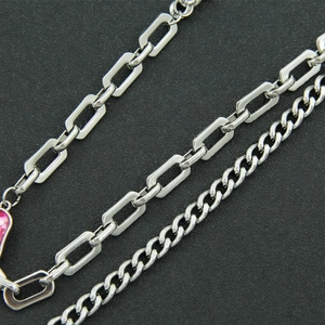 Detail of silver layered cuban link and paperclip chain with heart pendant