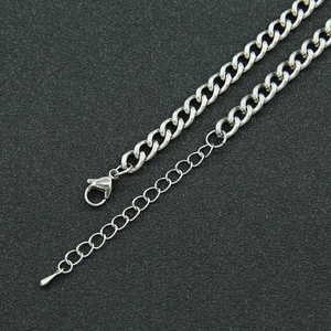 Close-up of adjustable silver curb chain with lobster clasp and droplet pendant