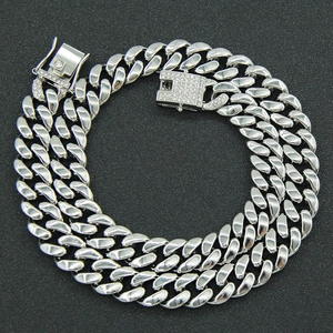Détail d'un collier chaîne cubaine argentée avec fermoir serti de strass brillants