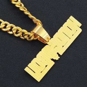 Gros plan d'une chaîne cubaine dorée et d'un pendentif rectangulaire à texture grillagée