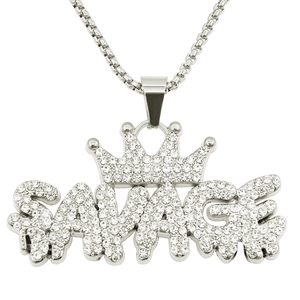 Close-up of iced out Savage letter pendant with crown and silver box chain detail